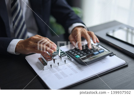 Silver Bullion Investment and Financial Analysis. Businessman Calculating Investment Returns with Silver Bars and Financial Documents. Silver Bullion Investment and Financial Analysis. Businessman Calculating Investment Returns with Silver Bars and Financial Documents. 139937502