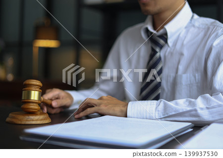 Lawyer Reviewing Contract and Documents with Gavel on Desk. 139937530