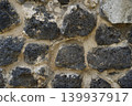 Dark porous basalt stone wall texture with light mortar joints 139937917