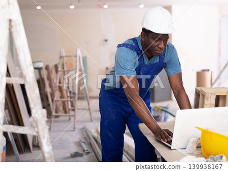 African american engineer checks a home renovation plan on a laptop 139938167