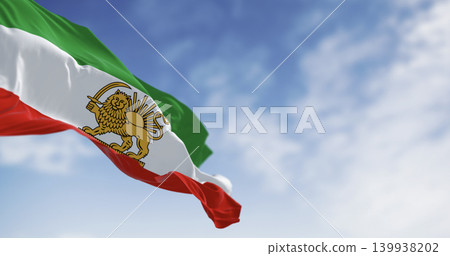 Iran Pahlavi era Lion and Sun flag waving against blue sky Iran Pahlavi era Lion and Sun flag waving against blue sky 139938202
