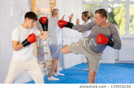 Two men training boxing and kicking in studio Two men training boxing and kicking in studio 139938288