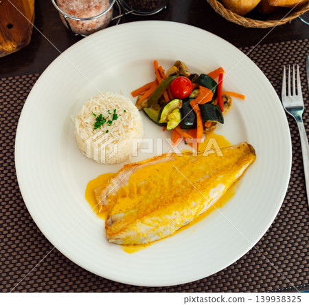 Sea bass fillet with curry sauce and basmati rice 139938325