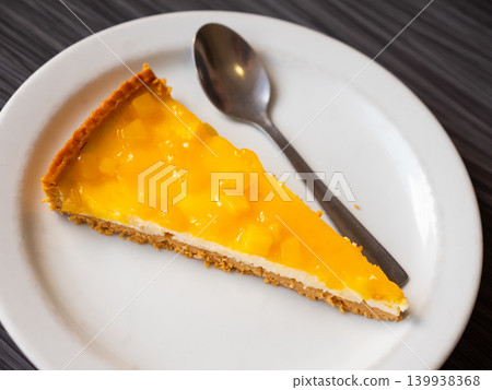 Piece of airy and delicate cheesecake pie, top layer of which decorated with small pineapple cubes Piece of airy and delicate cheesecake pie, top layer of which decorated with small pineapple cubes 139938368