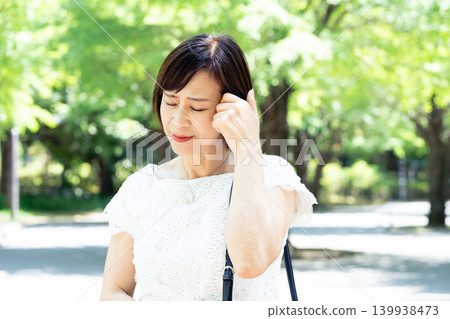 Middle-aged women who are concerned about sunburn outdoors 139938473