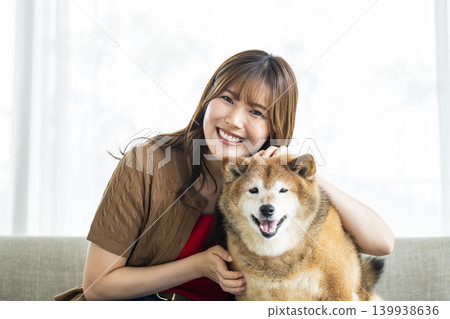 一隻柴犬和一位年輕女子正看著鏡頭。 一隻柴犬和一位年輕女子正看著鏡頭。 139938636