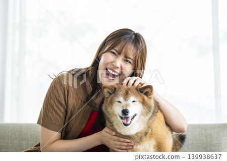 一隻柴犬和一位年輕女子正看著鏡頭。 一隻柴犬和一位年輕女子正看著鏡頭。 139938637