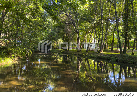Tranquil River Reflection at Parque de Lazer da Varzea in Portugal Tranquil River Reflection at Parque de Lazer da Varzea in Portugal 139939149