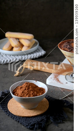 Tiramisu Ingredients with Cocoa Powder and Ladyfingers on Dark Stone Surface Tiramisu Ingredients with Cocoa Powder and Ladyfingers on Dark Stone Surface 139939160