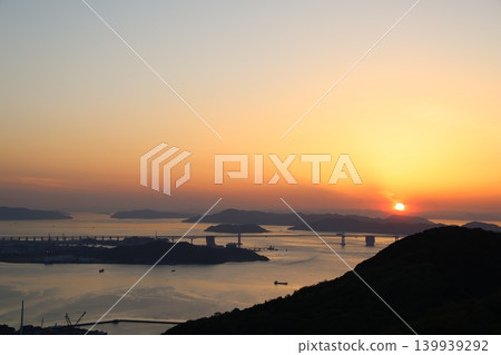 The Seto Ohashi Bridge at dusk and the sunset sky and sun setting over the Seto Inland Sea 1 The Seto Ohashi Bridge at dusk and the sunset sky and sun setting over the Seto Inland Sea 1 139939292