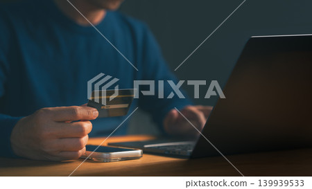 Adult man using a credit card with a laptop, representing digital banking, financial transactions, pay off the credit card, and secure internet shopping technology. Online payment and e-commerce Adult man using a credit card with a laptop, representing digital banking, financial transactions, pay off the credit card, and secure internet shopping technology. Online payment and e-commerce 139939533