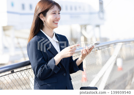 A businesswoman heading out on a business trip, pulling her suitcase. 139939540