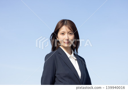 一位身穿西裝的女士欣喜若狂，擺出了勝利的姿勢。 139940016
