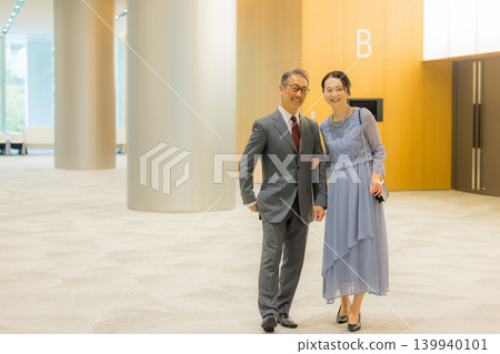 A middle-aged couple heading to an event hall A middle-aged couple heading to an event hall 139940101
