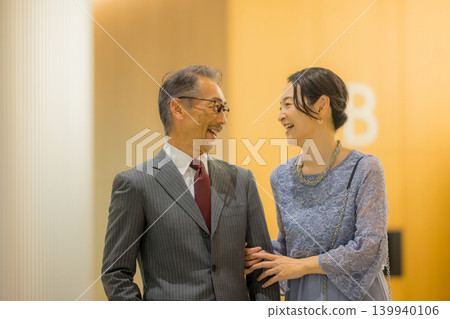 A middle-aged couple heading to an event hall A middle-aged couple heading to an event hall 139940106