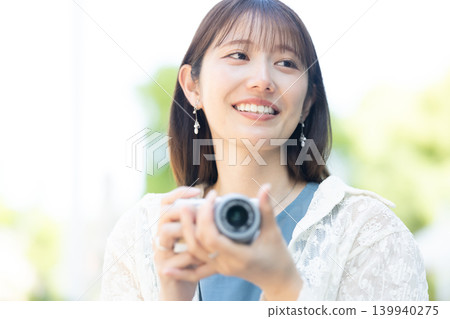 Cute woman holding a camera Cute woman holding a camera 139940275