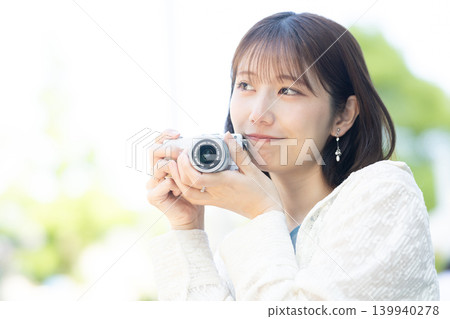 拿著照相機的逗人喜愛的婦女 拿著照相機的逗人喜愛的婦女 139940278