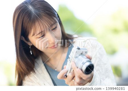 拿著照相機的逗人喜愛的婦女 拿著照相機的逗人喜愛的婦女 139940281