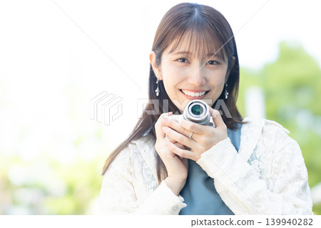 拿著照相機的逗人喜愛的婦女 拿著照相機的逗人喜愛的婦女 139940282