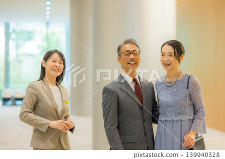工作人員引導一對中年夫婦前往活動大廳。 139940328