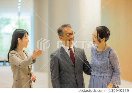 工作人員引導一對中年夫婦前往活動大廳。 139940329