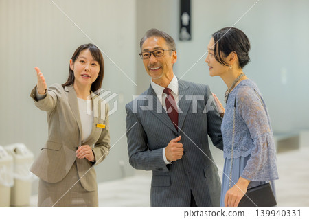 工作人員引導一對中年夫婦前往活動大廳。 139940331