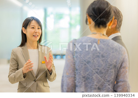 工作人員引導一對中年夫婦前往活動大廳。 139940334