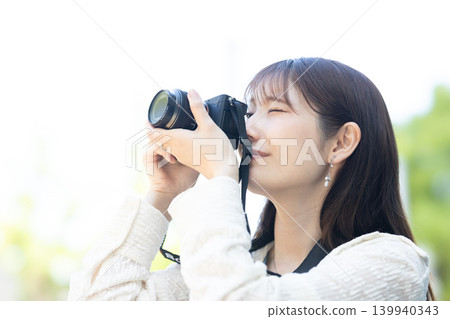 Cute woman holding a camera 139940343