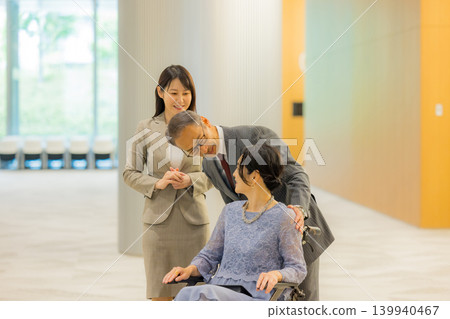 工作人員引導一對中年夫婦前往活動大廳。 工作人員引導一對中年夫婦前往活動大廳。 139940467