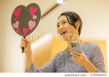 A middle-aged woman who finds happiness through her fan activities. A middle-aged woman who finds happiness through her fan activities. 139940650