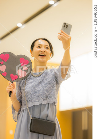 A middle-aged woman who finds happiness through her fan activities. 139940653