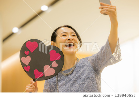 A middle-aged woman who finds happiness through her fan activities. 139940655