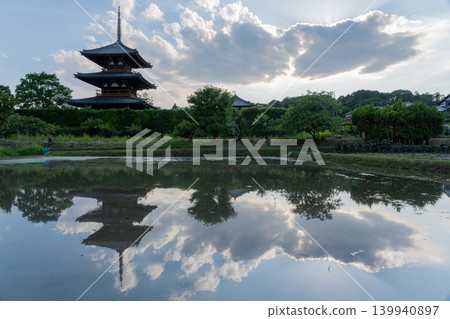 一張照片展現了伊卡魯加初夏時節，溫暖的稻田映照著法喜寺的景色。 139940897