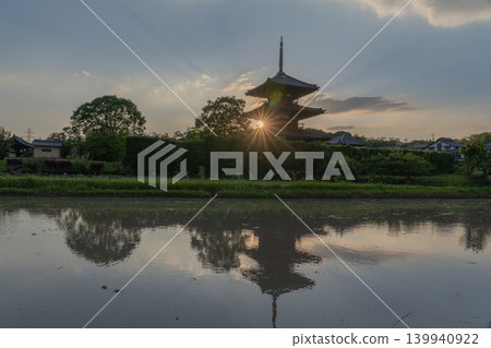 A photograph of the warming rice paddies reflecting Hokiji Temple, a scene from early summer in Ikaruga. A photograph of the warming rice paddies reflecting Hokiji Temple, a scene from early summer in Ikaruga. 139940922