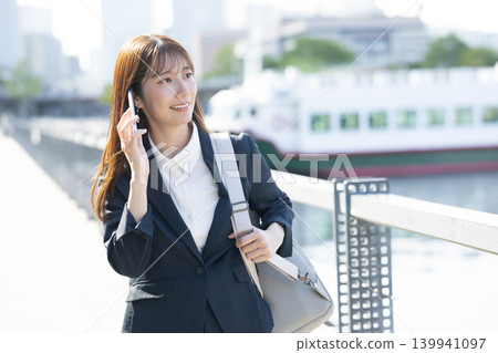 A woman in a suit stops and thinks. 139941097