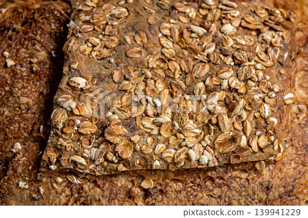 Sprinkling oats on bread 139941229