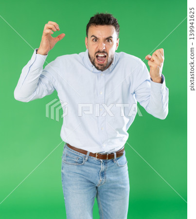 Adult man angry and yelling in front of green screen Adult man angry and yelling in front of green screen 139941625
