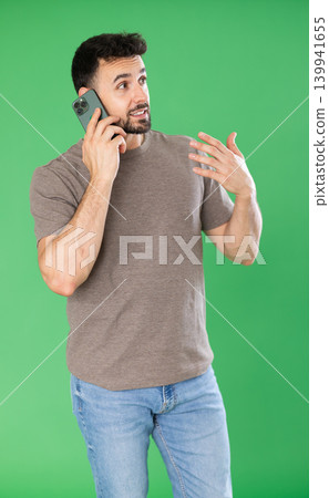 Adult positive man talks emotionally on mobile phone. Chroma key compositing. Adult positive man talks emotionally on mobile phone. Chroma key compositing. 139941655