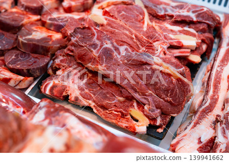 Fresh raw veal chops, tenderloin, short ribs and steaks in showcase Fresh raw veal chops, tenderloin, short ribs and steaks in showcase 139941662