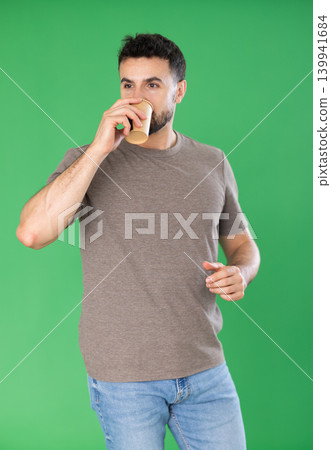 Young man and coffee break on green screen background Young man and coffee break on green screen background 139941684