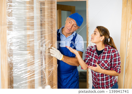 Woman talking with worker about door install 139941741