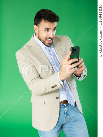 Adult man taking photo or scanning QR code in front of green screen Adult man taking photo or scanning QR code in front of green screen 139941830