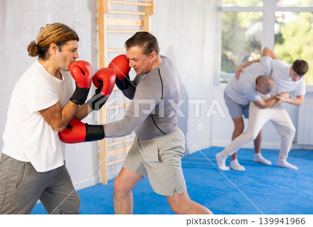 Two men training boxing fight in studio Two men training boxing fight in studio 139941966