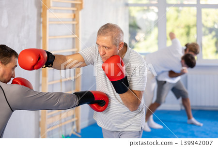 Portrait of experienced sportsmen competing in boxing gloves Portrait of experienced sportsmen competing in boxing gloves 139942007