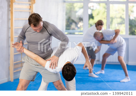 Two men training judo technique in studio Two men training judo technique in studio 139942011