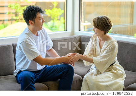 A couple holding hands on a sofa A couple holding hands on a sofa 139942522