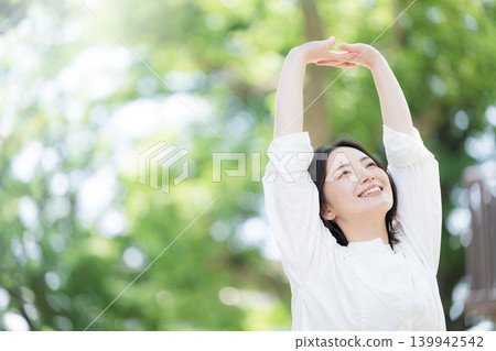 A healthy lifestyle image of a woman refreshing herself by taking a deep breath amidst the fresh greenery of nature. A healthy lifestyle image of a woman refreshing herself by taking a deep breath amidst the fresh greenery of nature. 139942542