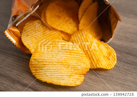 Potato chips, delicious BBQ seasoning spicy for crips, thin slice deep fried snack fast food in open bag. Potato chips, delicious BBQ seasoning spicy for crips, thin slice deep fried snack fast food in open bag. 139942728