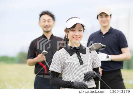 一位女士微笑著學習打高爾夫球;與她的高爾夫教練和朋友們一起享受健康的生活方式;她的笑容直視著鏡頭。 一位女士微笑著學習打高爾夫球;與她的高爾夫教練和朋友們一起享受健康的生活方式;她的笑容直視著鏡頭。 139943179
