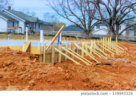 Workers are preparing wooden forms for slab foundation of new building in neighborhood during Workers are preparing wooden forms for slab foundation of new building in neighborhood during 139943326